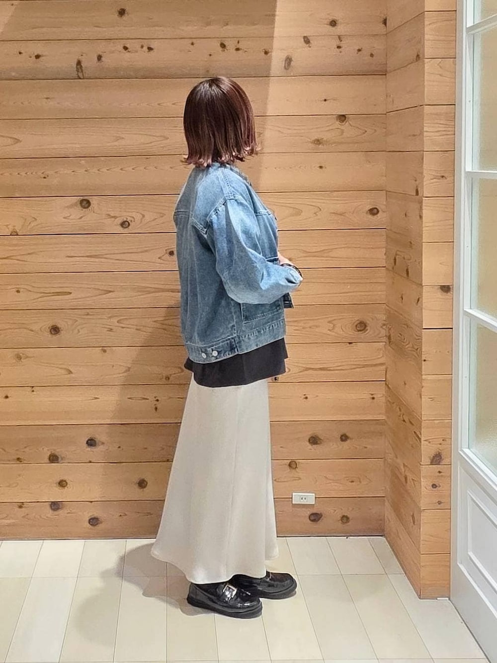 ブラック系のローファー、シルバー系のハンドバッグ、グレー系のスカートを着用したレディースの春コーディネートの2枚目の写真