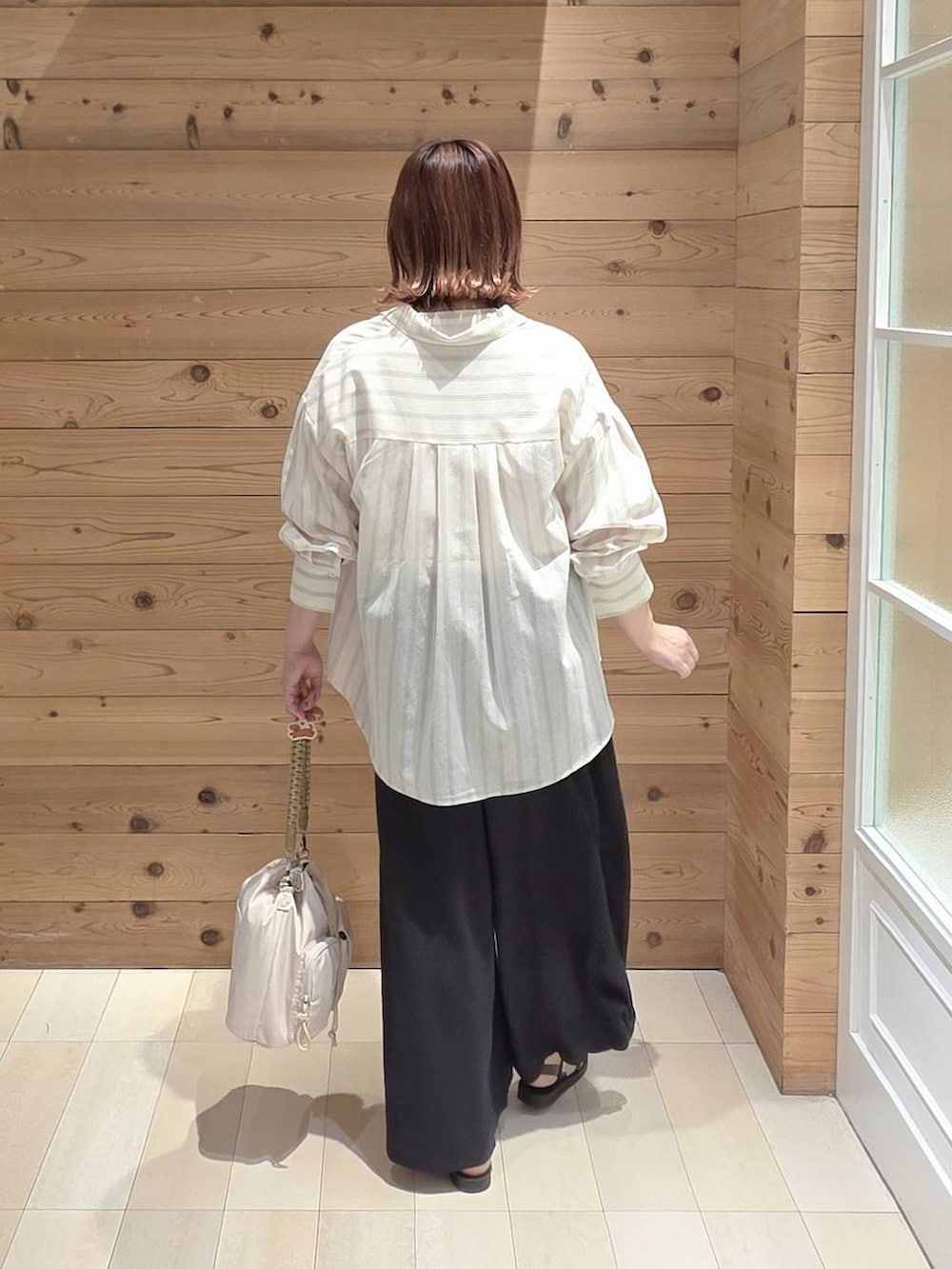 グレー系のシャツ/ブラウス、ブラック系のその他パンツ、ホワイト系のTシャツ/カットソーを着用したレディースの夏コーディネートの3枚目の写真