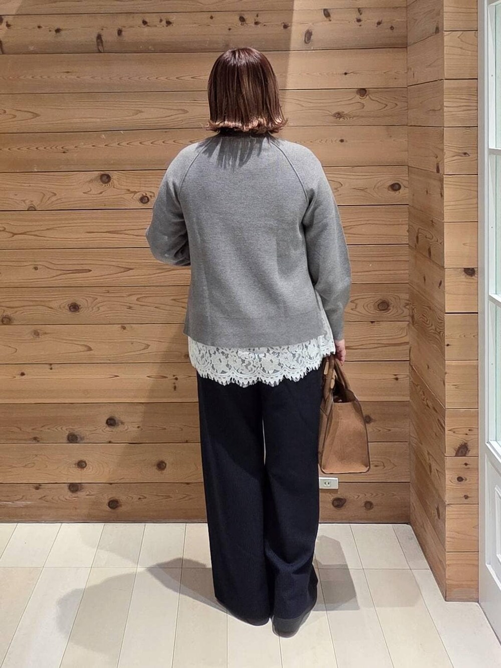 ベージュ系のダウンジャケット/コート、ベージュ系のショルダーバッグ、グレー系のニット/セーターを着用したレディースの冬コーディネートの3枚目の写真