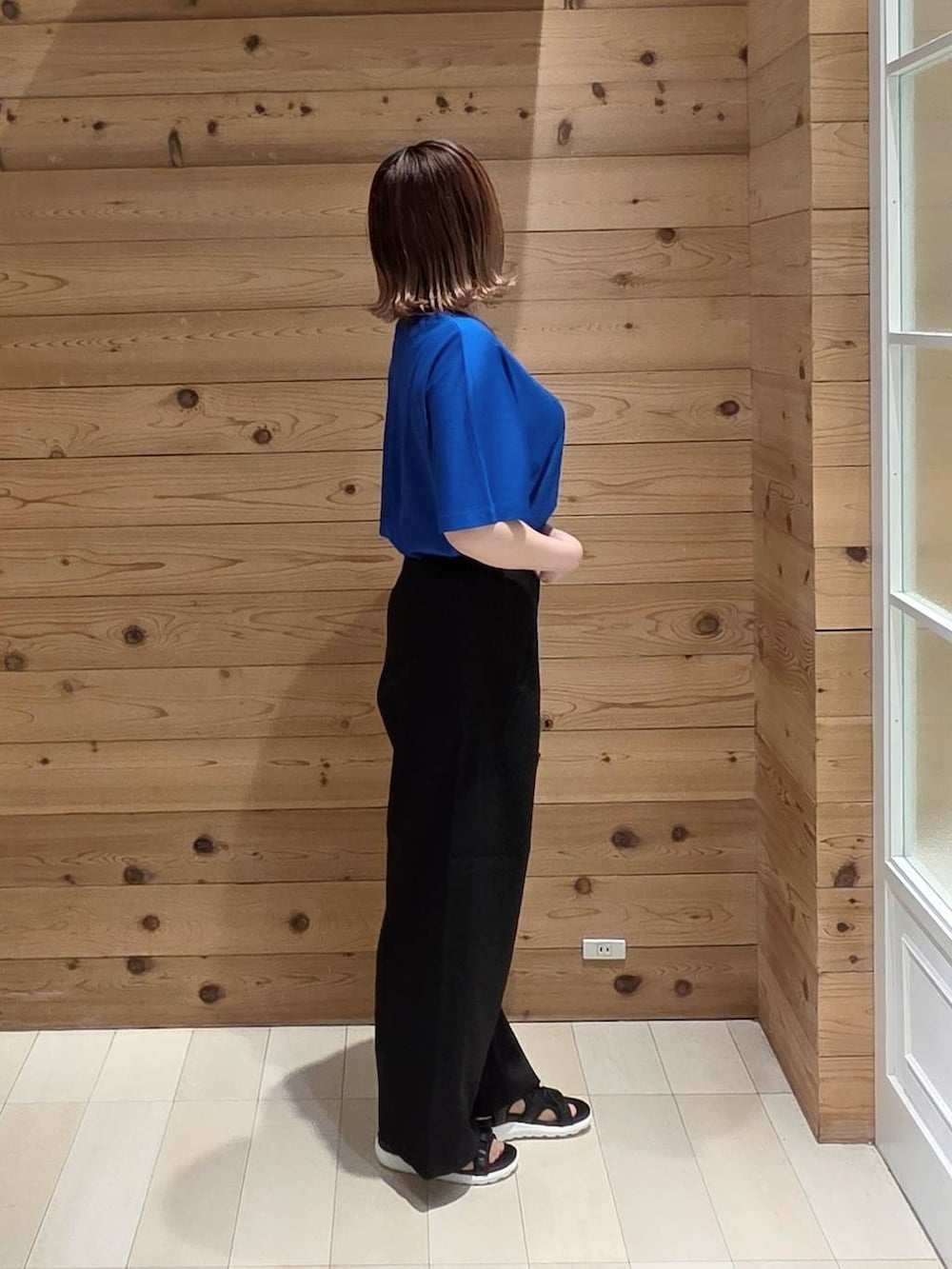 ブラック系のその他パンツ、ブルー系のTシャツ/カットソー、ブラック系のクラッチバッグを着用したレディースの夏コーディネートの2枚目の写真