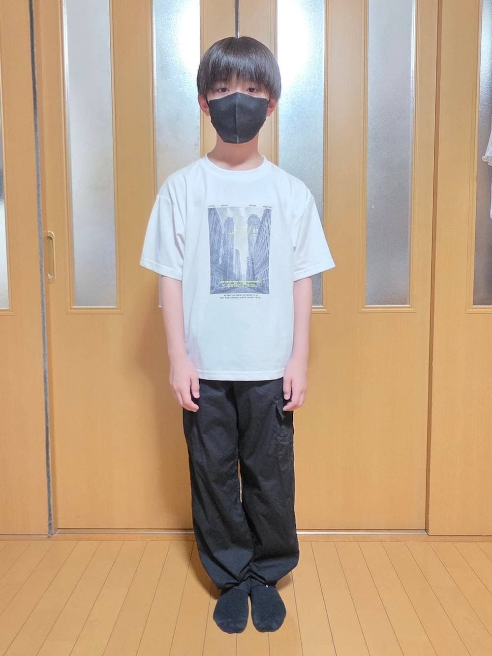 ブラック系のカーゴパンツ、グリーン系のMA-1、ホワイト系のTシャツ/カットソーを着用したキッズの春コーディネートの4枚目の写真