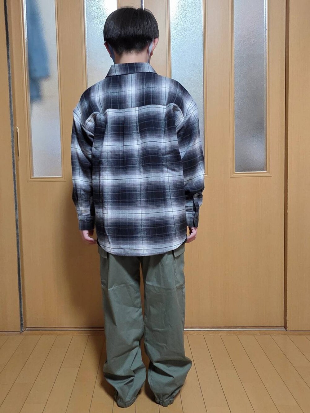 ブラック系のシャツ/ブラウス、グリーン系のカーゴパンツ、ブラック系のTシャツ/カットソーを着用したキッズの秋コーディネートの3枚目の写真