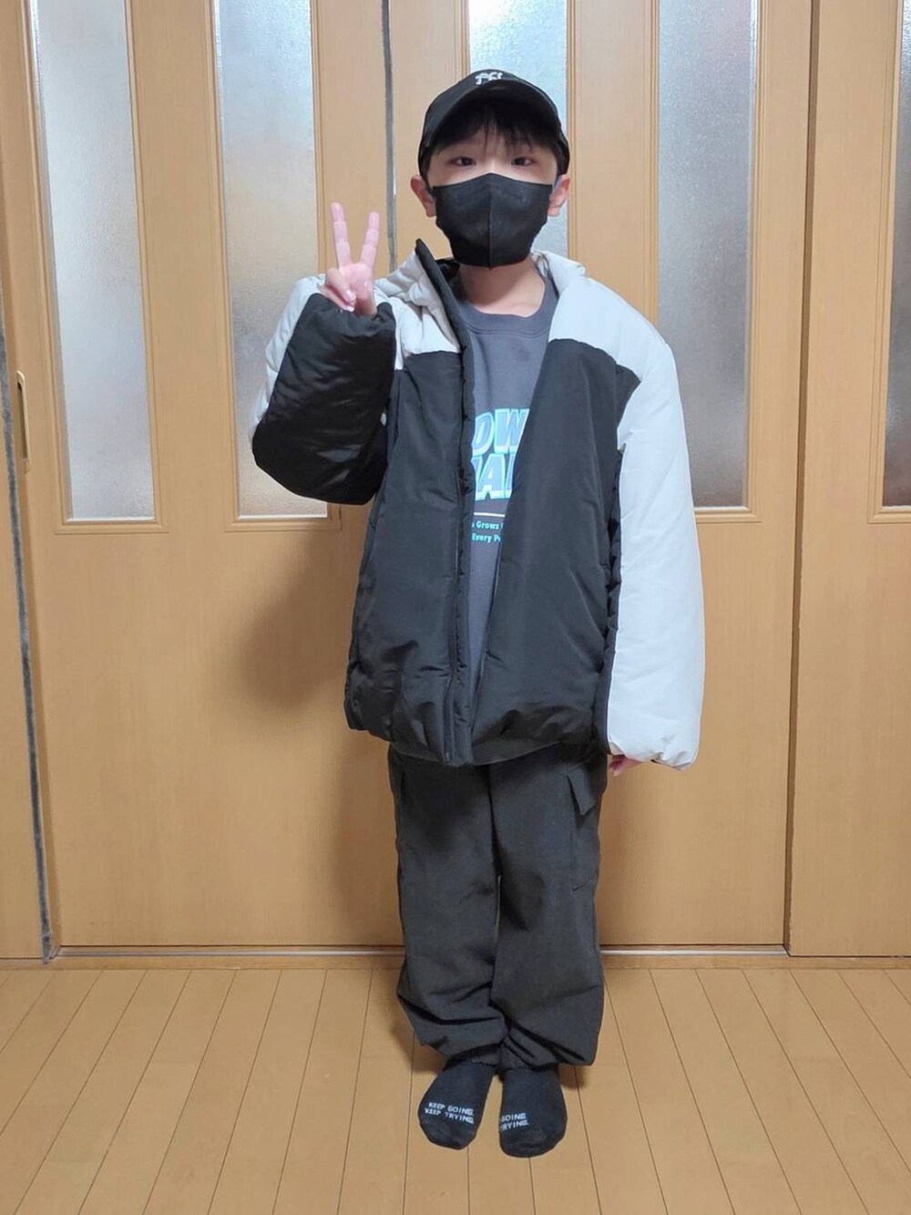 ベージュ系のブルゾン、ブラック系のカーゴパンツ、グレー系のスウェットを着用したキッズの冬コーディネートの4枚目の写真