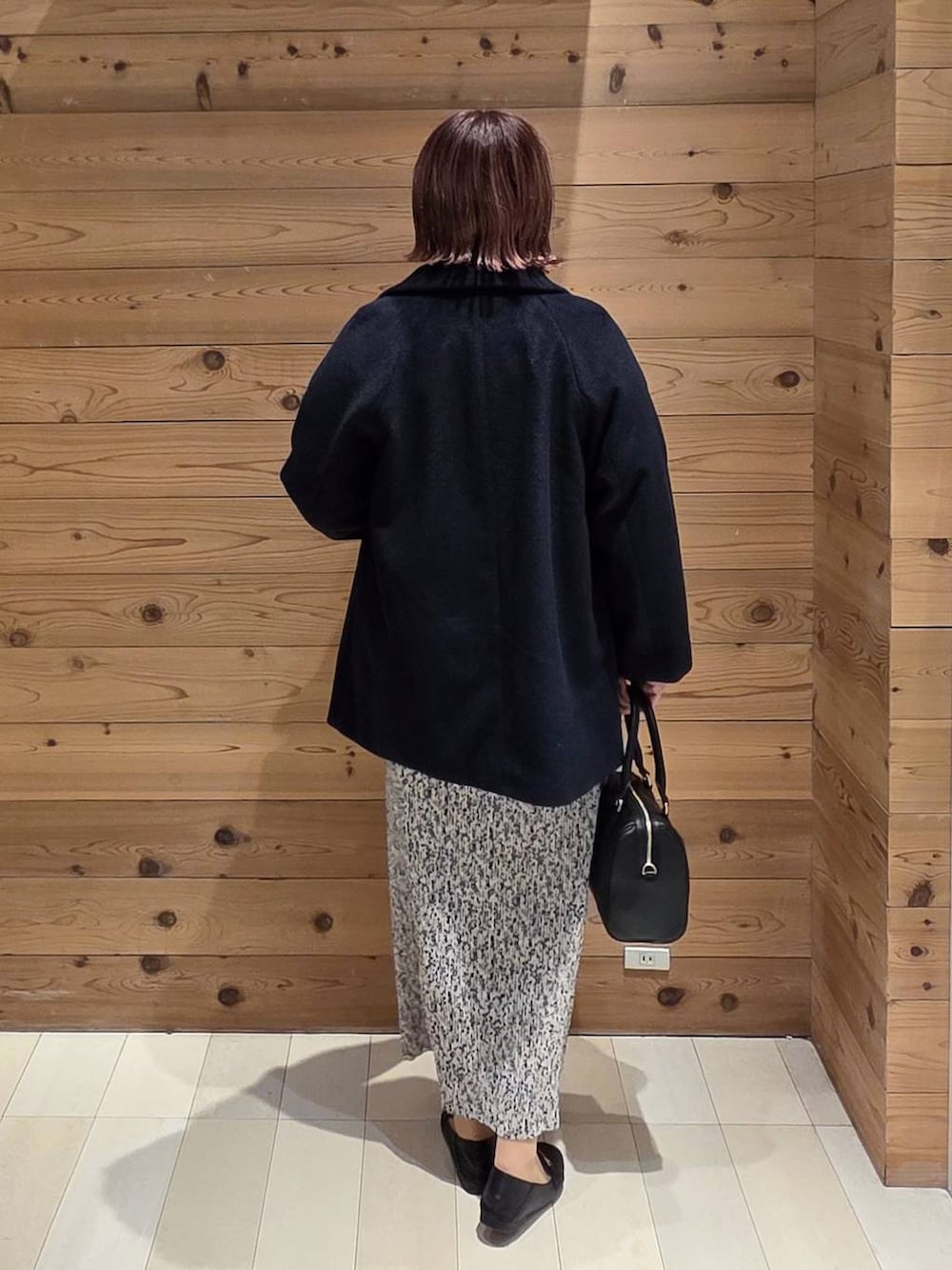 ブラック系のローファー、ブルー系のチェスターコート、グレー系のカーディガン/ボレロを着用したレディースの秋コーディネートの3枚目の写真