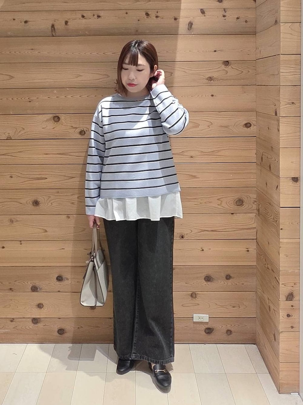 ブラック系のローファー、ホワイト系のショルダーバッグ、ブラック系のデニムパンツを着用したレディースの春コーディネートの4枚目の写真