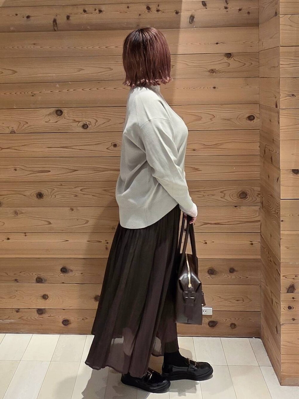 ブラック系のローファー、ブラウン系のボストンバッグ、ベージュ系のスウェットを着用したレディースの秋コーディネートの2枚目の写真