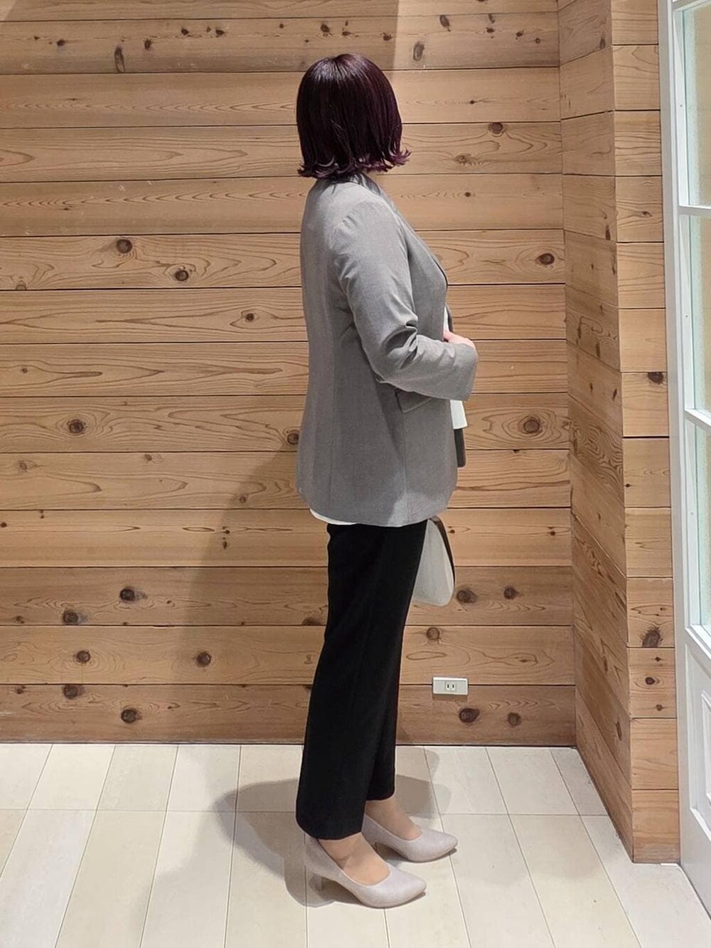 ホワイト系のショルダーバッグ、ホワイト系のパンプス、ブラック系のセットアップを着用したレディースの春コーディネートの2枚目の写真