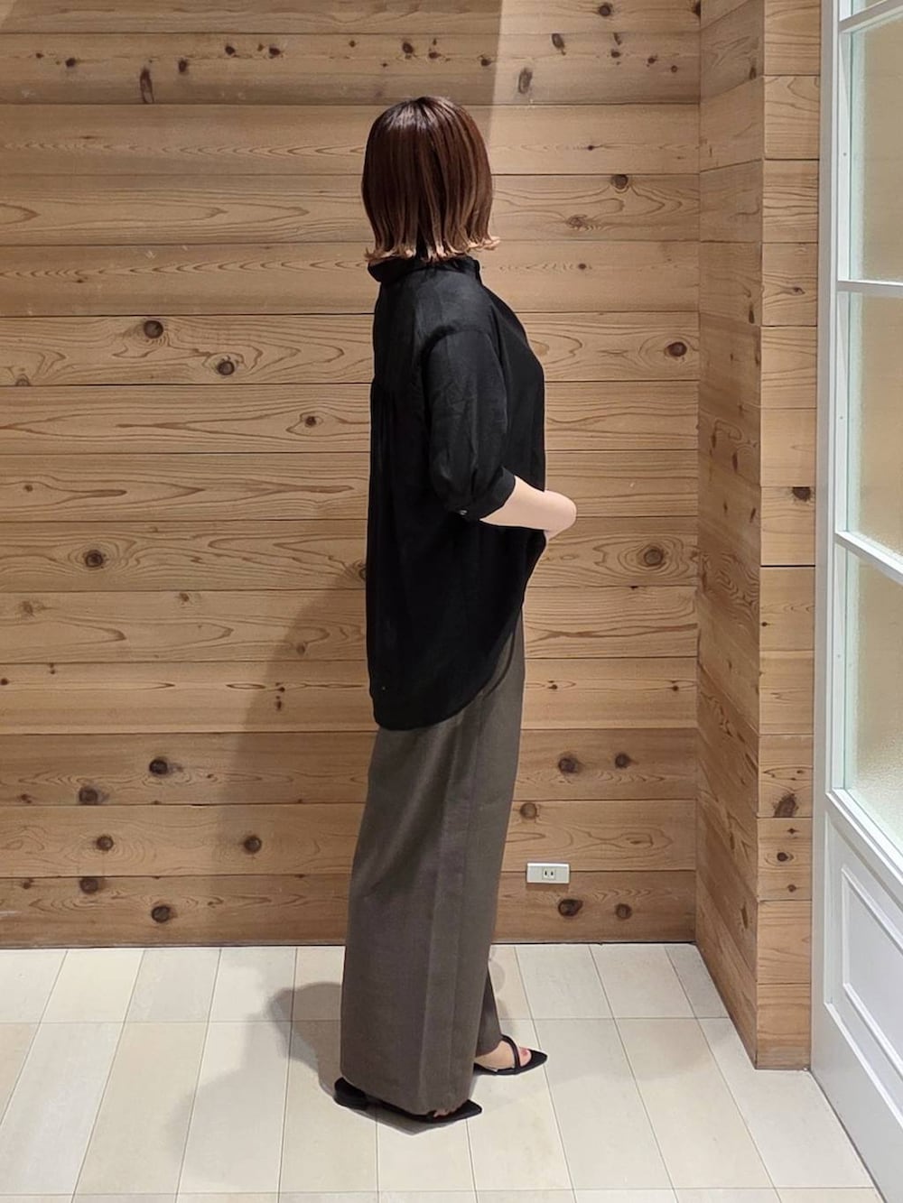 ホワイト系のハンドバッグ、ブラウン系のその他パンツ、ホワイト系のタンクトップを着用したレディースの夏コーディネートの2枚目の写真