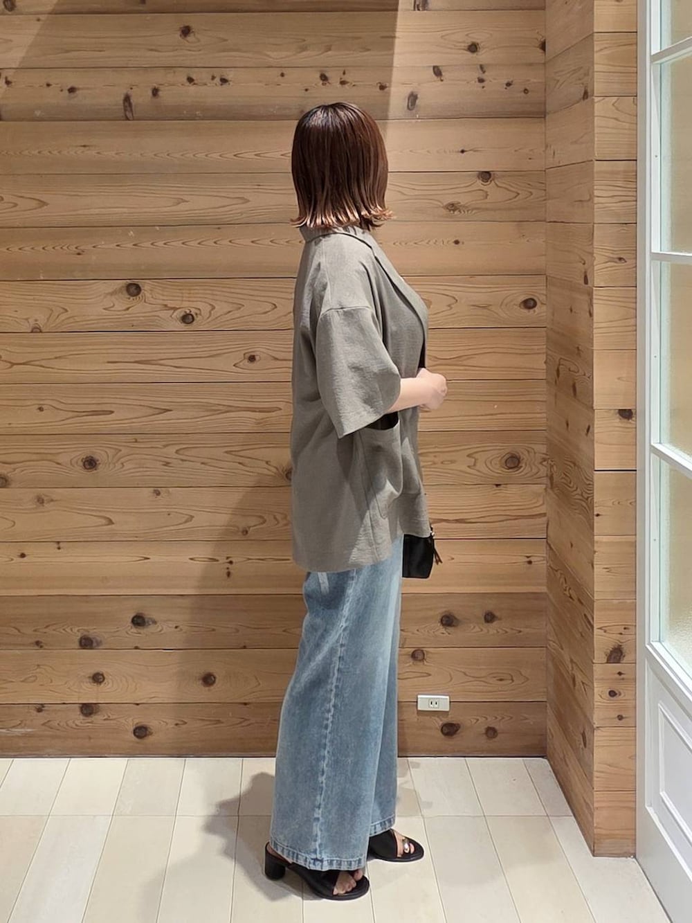 ブルー系のデニムパンツ、ブラウン系のテーラードジャケット、ホワイト系のTシャツ/カットソーを着用したレディースの夏コーディネートの2枚目の写真
