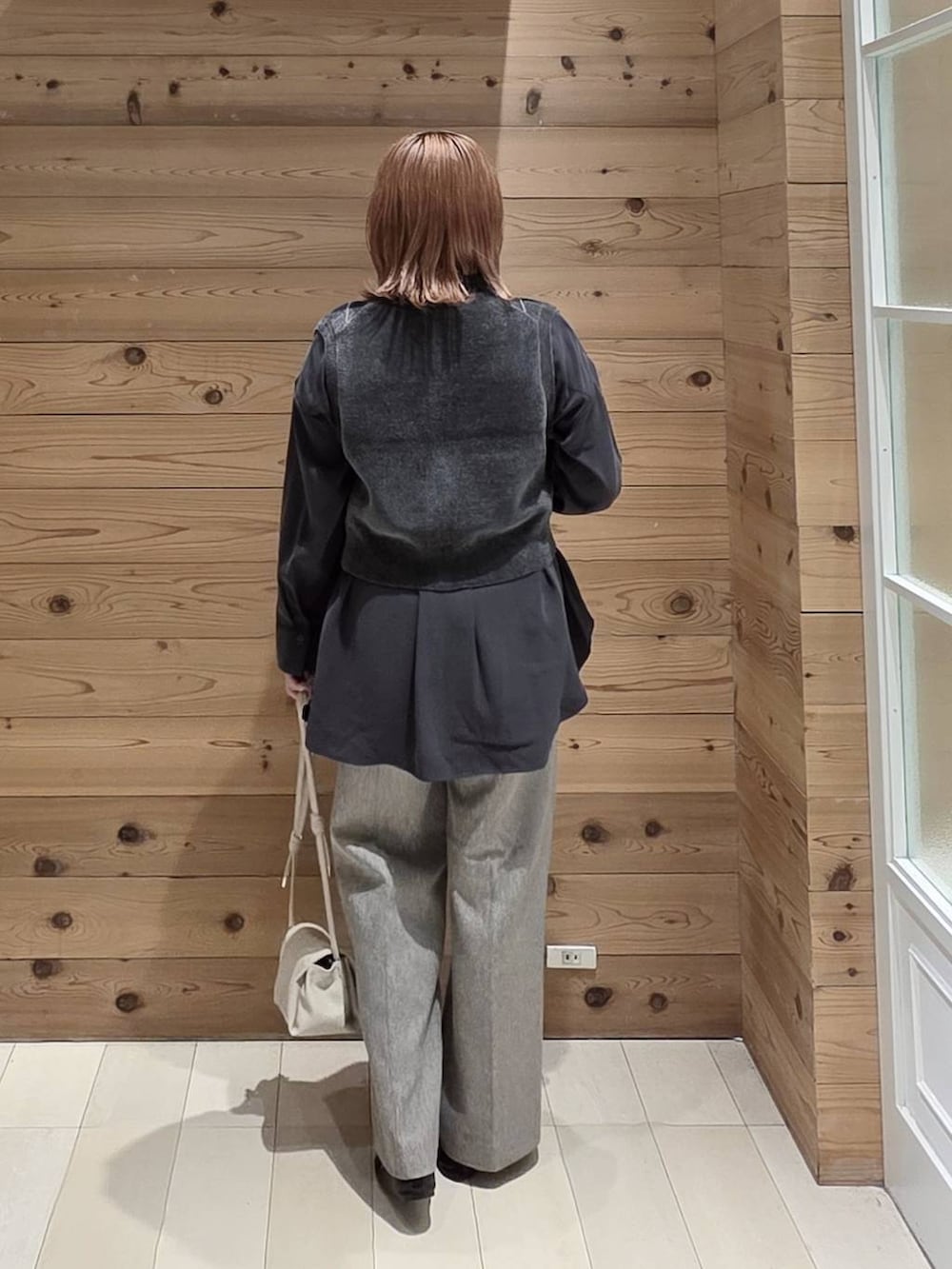 グレー系のベスト、グレー系のシャツ/ブラウス、ブラック系のバレエシューズを着用したレディースの秋コーディネートの3枚目の写真