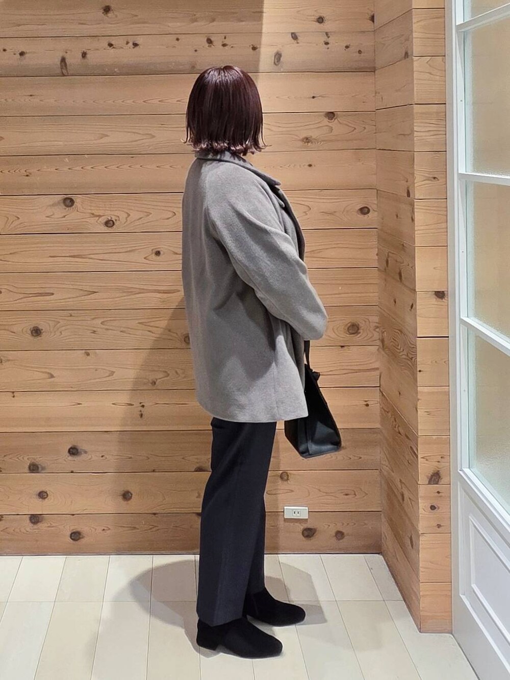 ブラック系のショルダーバッグ、ブラウン系のチェスターコート、ブルー系のその他パンツを着用したレディースの冬コーディネートの2枚目の写真