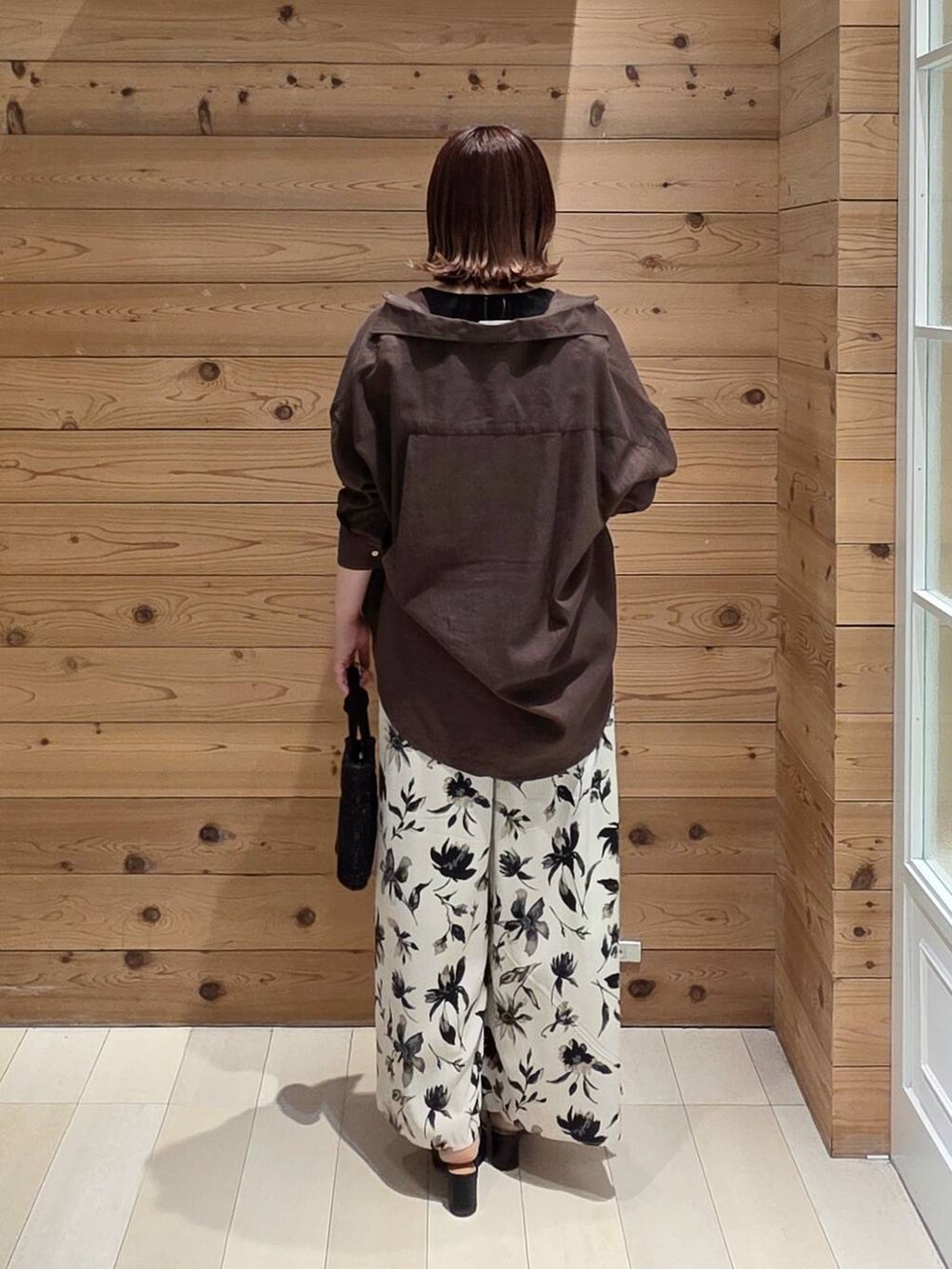 ブラウン系のシャツ/ブラウス、ホワイト系のその他パンツ、ブラック系のタンクトップを着用したレディースの春コーディネートの3枚目の写真