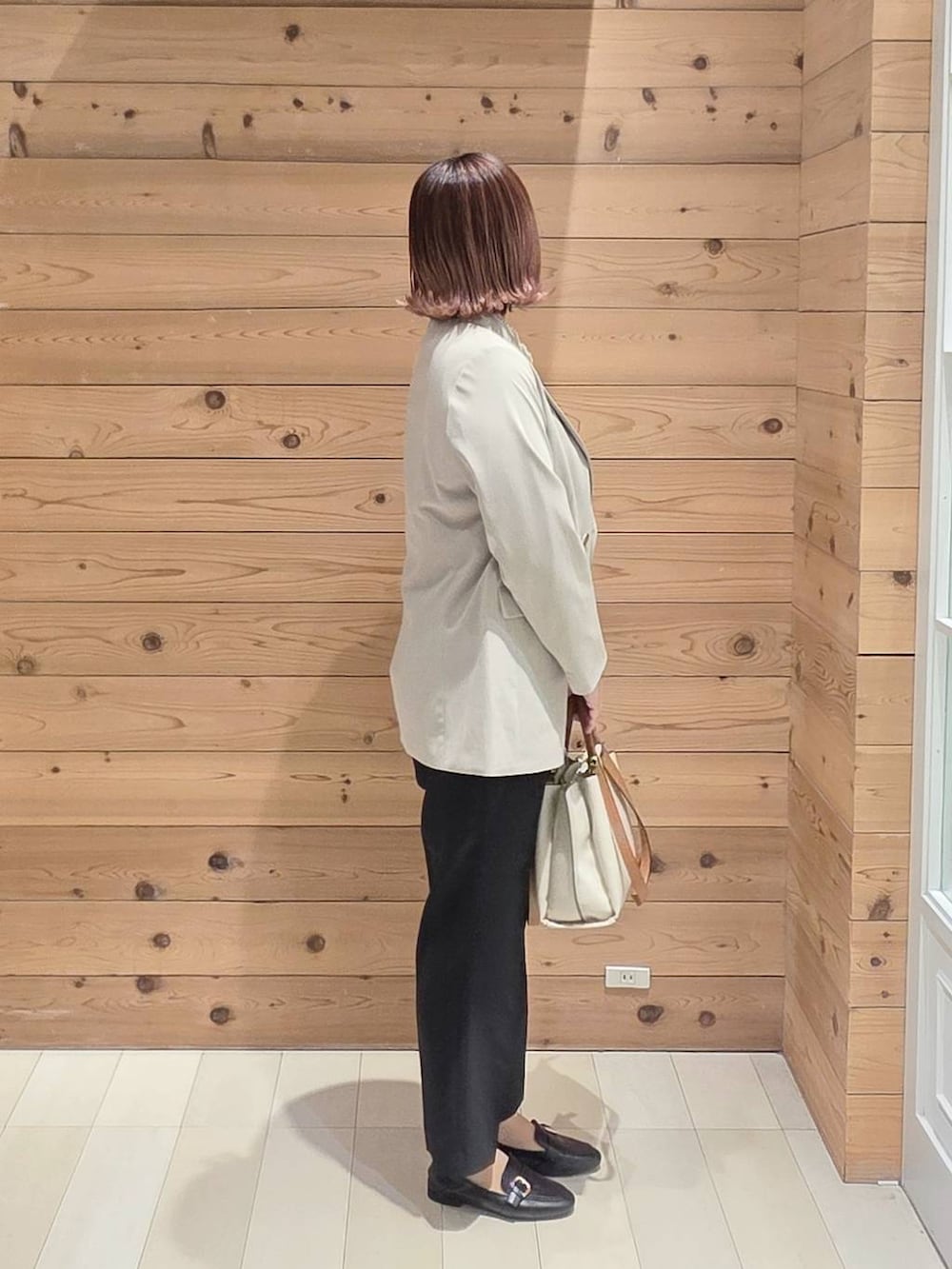 ブラック系のローファー、ブルー系のシャツ/ブラウス、ホワイト系のトートバッグを着用したレディースの春コーディネートの2枚目の写真