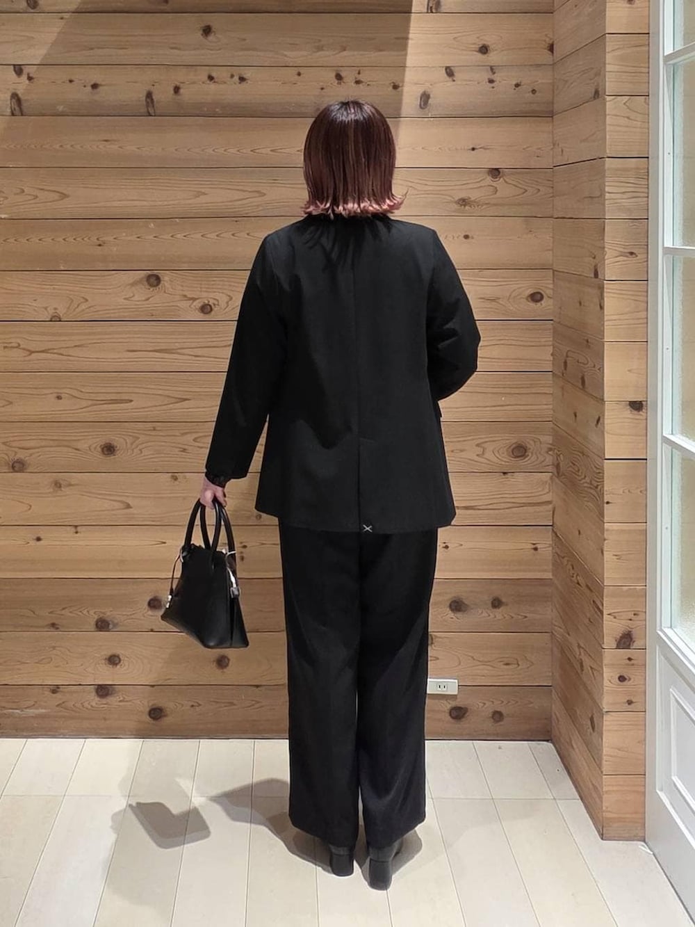 ブラック系のローファー、ブラック系のショルダーバッグ、ブラック系のTシャツ/カットソーを着用したレディースの冬コーディネートの3枚目の写真