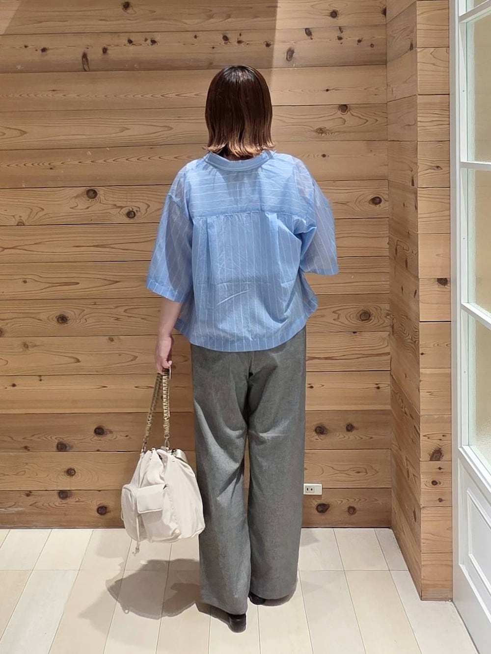 グレー系のその他パンツ、ブルー系のシャツ/ブラウス、ホワイト系のタンクトップを着用したレディースの夏コーディネートの3枚目の写真
