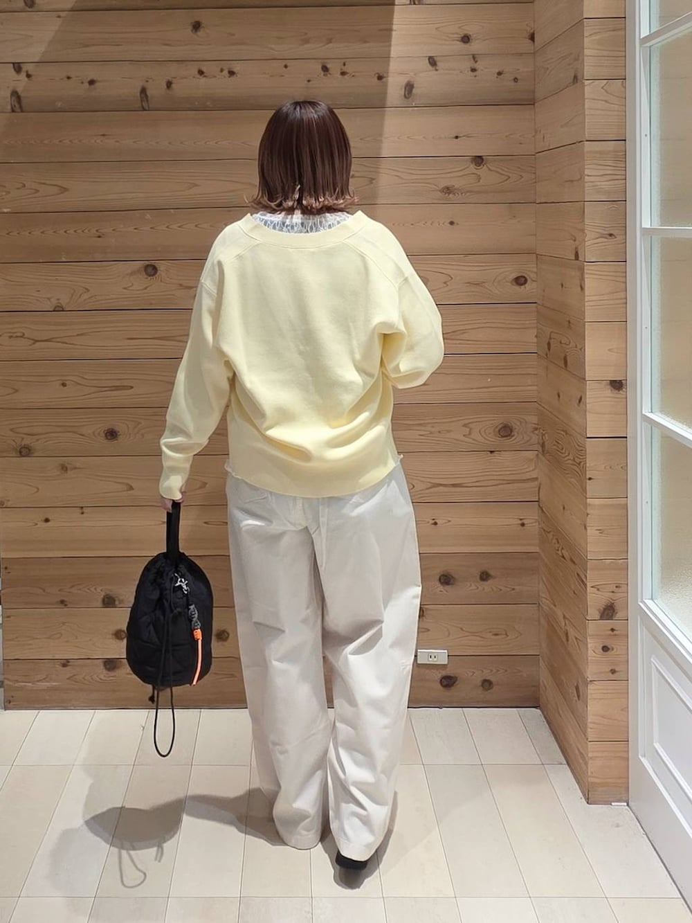 ブラック系のローファー、ブラック系のハンドバッグ、イエロー系のカーディガン/ボレロを着用したレディースの春コーディネートの3枚目の写真