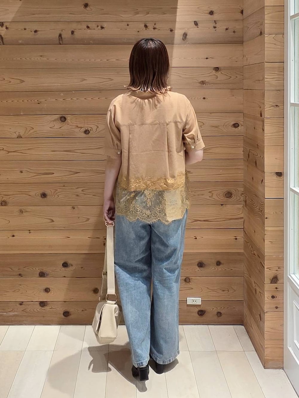 ブルー系のデニムパンツ、ホワイト系のタンクトップ、ブラック系のサンダルを着用したレディースの夏コーディネートの3枚目の写真