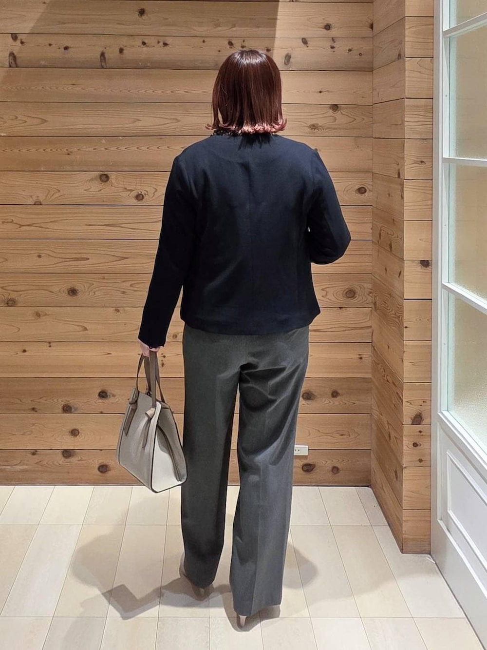 ホワイト系のショルダーバッグ、ホワイト系のパンプス、ブラック系のシャツ/ブラウスを着用したレディースの冬コーディネートの3枚目の写真