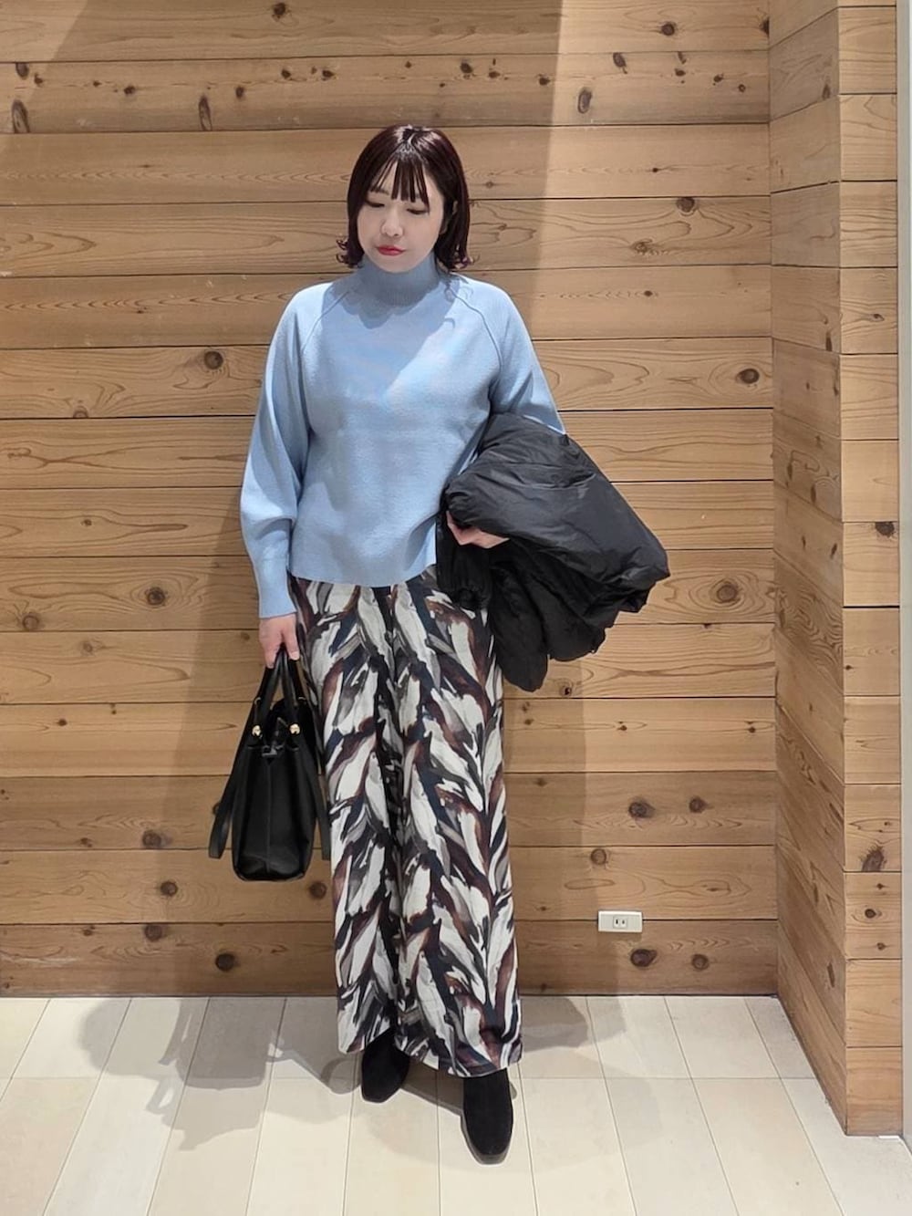 ブラック系のダウンジャケット/コート、ブルー系のニット/セーター、その他のブーツを着用したレディースの冬コーディネートの4枚目の写真