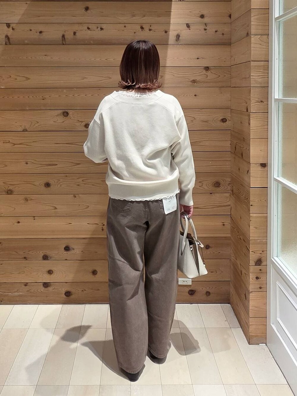 ブラック系のパンプス、ホワイト系のショルダーバッグ、ブラック系のマウンテンパーカーを着用したレディースの春コーディネートの3枚目の写真