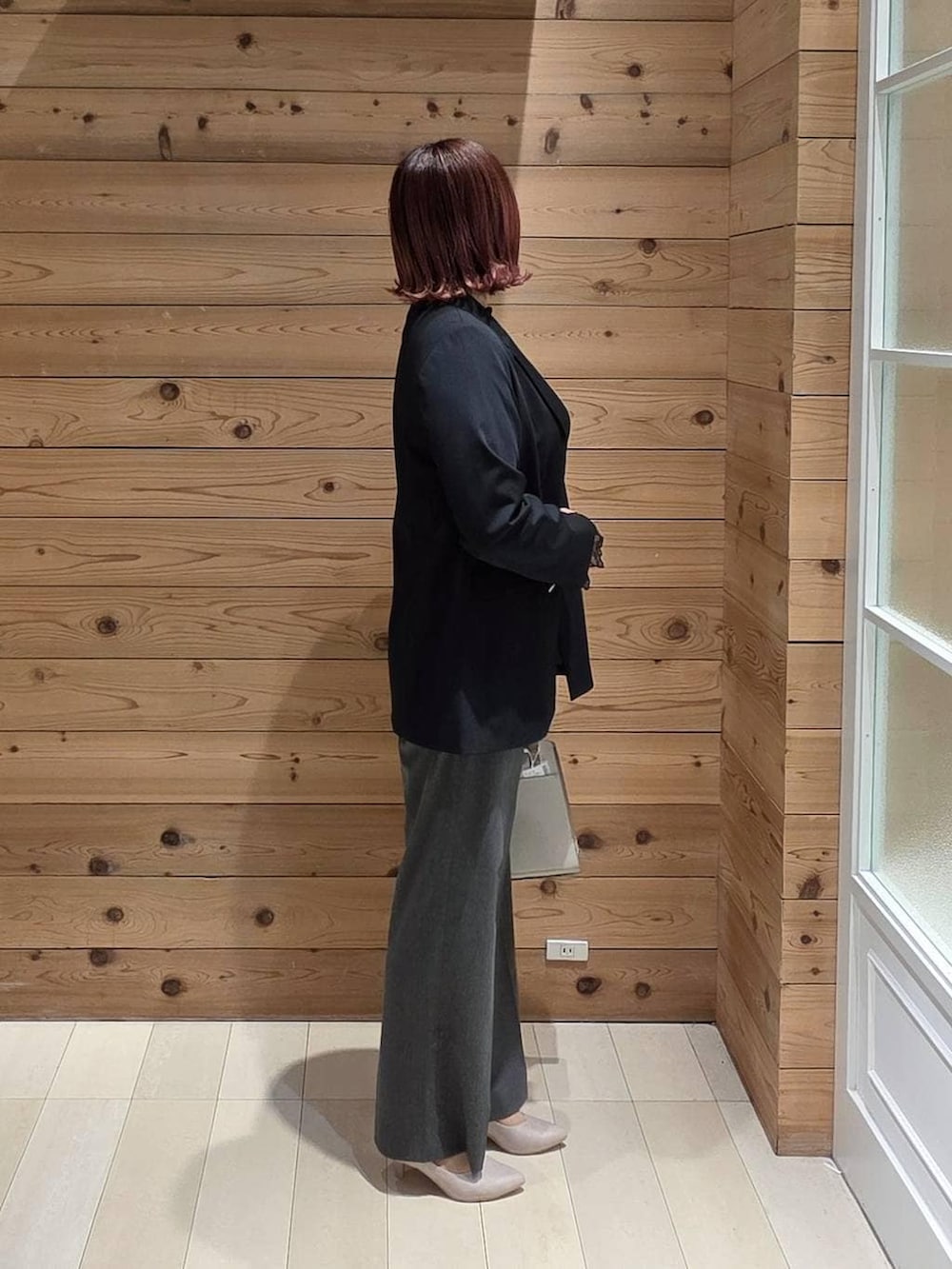 ホワイト系のショルダーバッグ、ホワイト系のパンプス、ブラック系のシャツ/ブラウスを着用したレディースの冬コーディネートの2枚目の写真