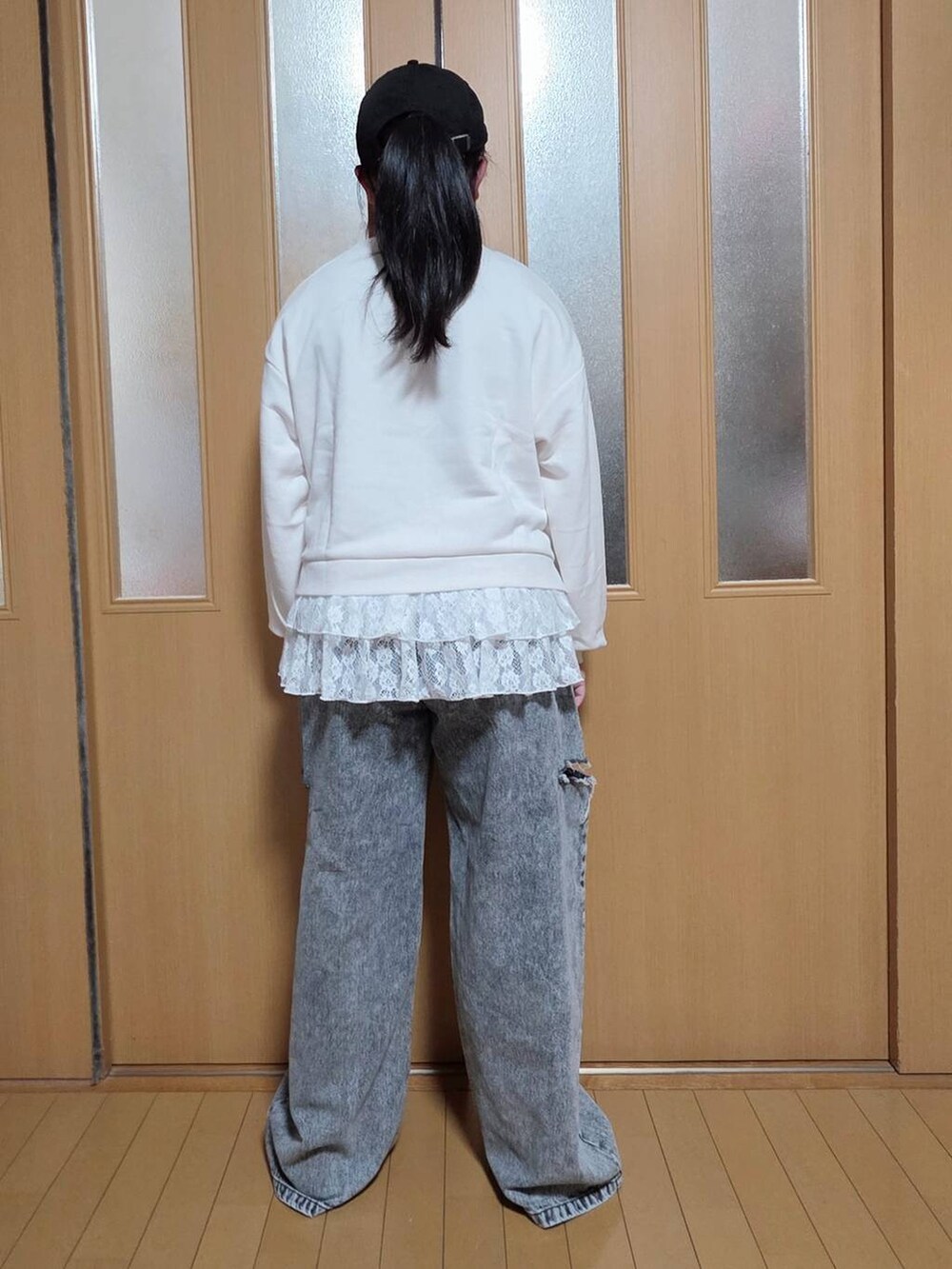 ブラック系のデニムパンツ、ホワイト系のスウェット、ブラック系のキャップを着用したキッズの秋コーディネートの3枚目の写真