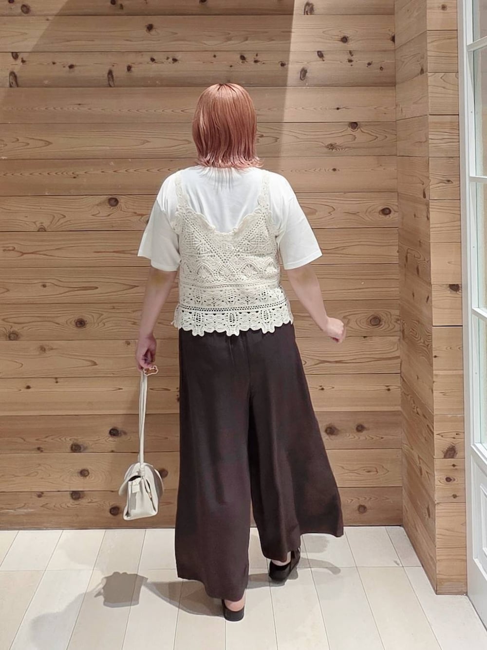 ベージュ系のショルダーバッグ、ブラウン系のその他パンツ、ホワイト系のTシャツ/カットソーを着用したレディースの夏コーディネートの3枚目の写真