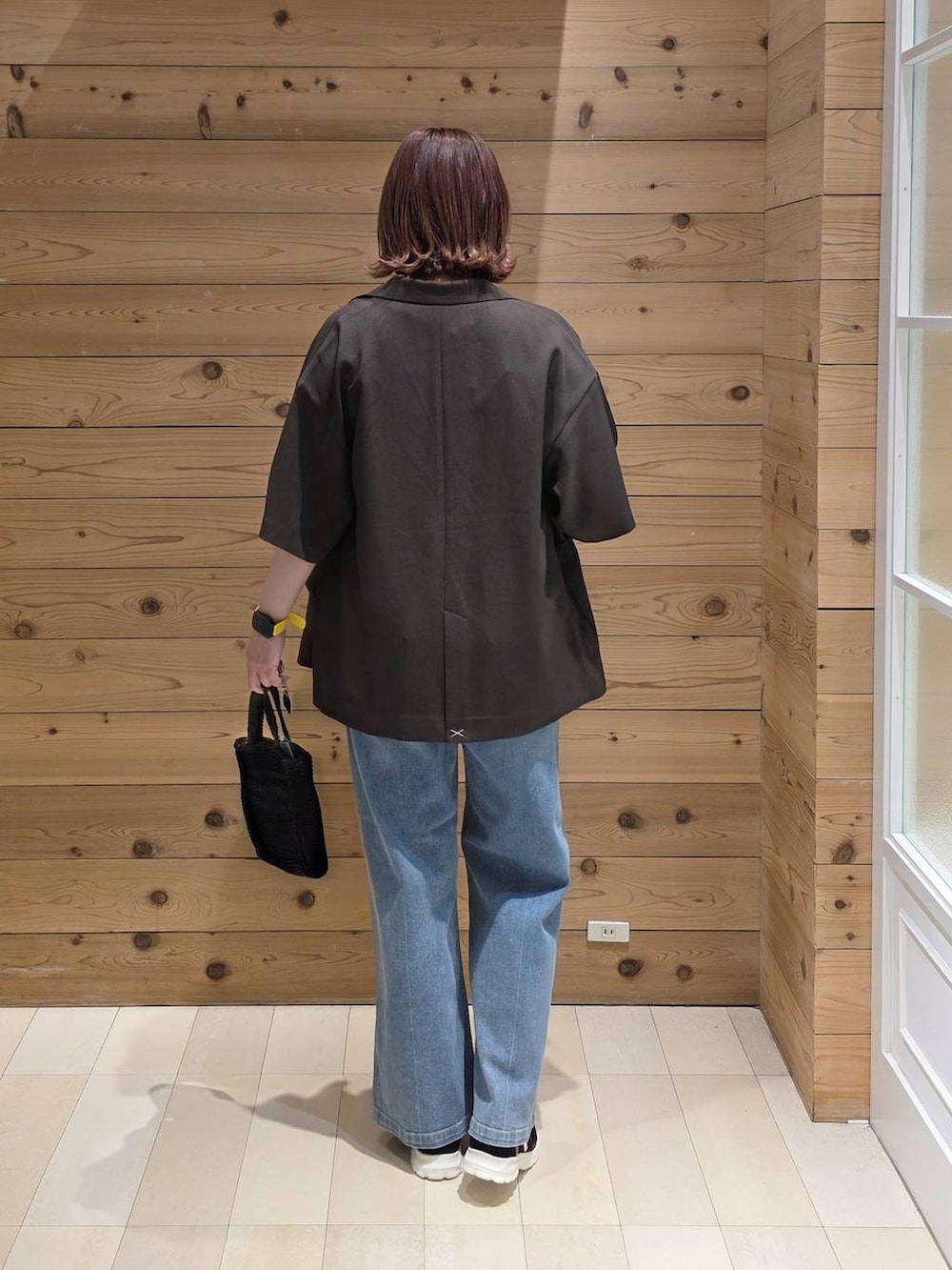 ブラック系のスニーカー、ブルー系のデニムパンツ、ブラック系のタンクトップを着用したレディースの春コーディネートの3枚目の写真