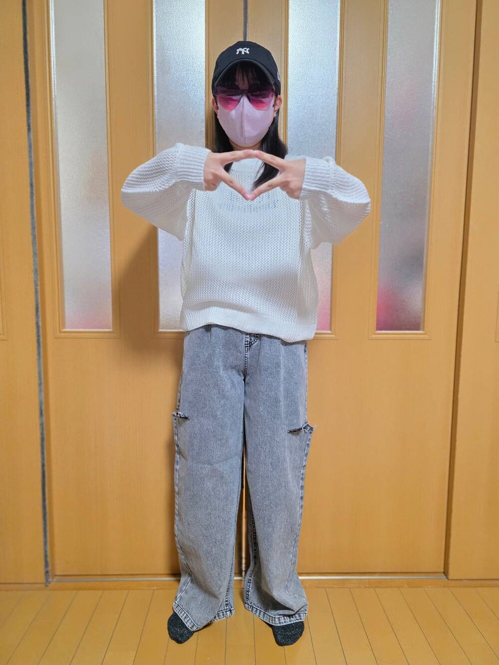 ブラック系のデニムパンツ、ホワイト系のニット/セーター、ブラック系のキャップを着用したキッズの秋コーディネートの5枚目の写真