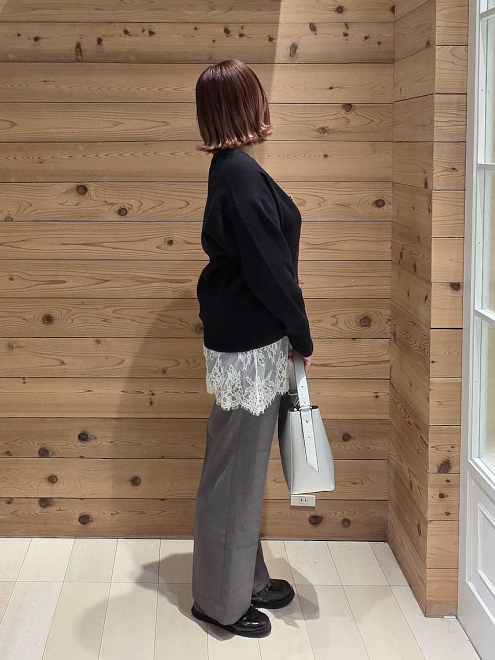 ブラック系のローファー、シルバー系のショルダーバッグ、ブラウン系のその他パンツを着用したレディースの春コーディネートの2枚目の写真