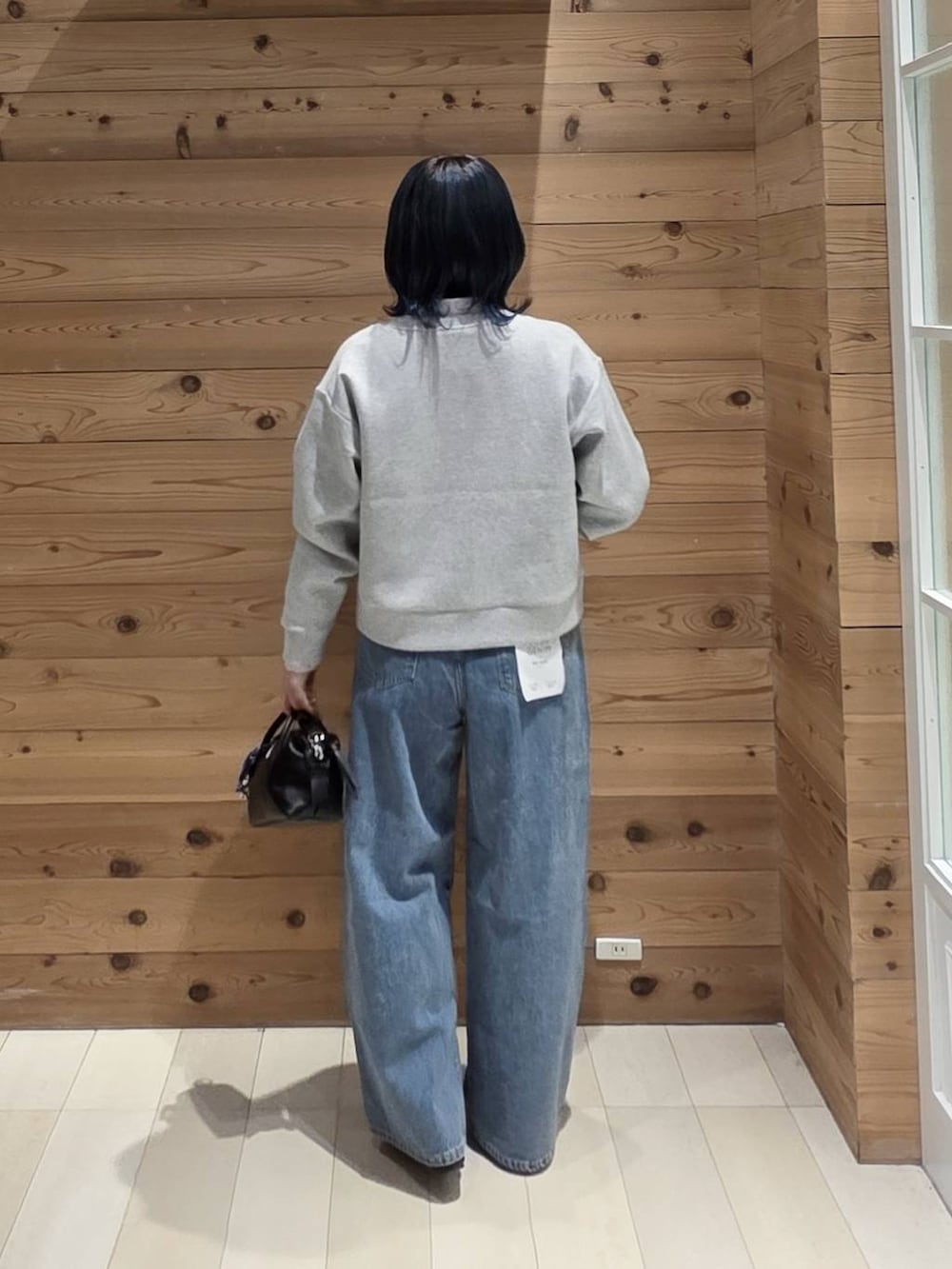 ブルー系のデニムパンツ、グレー系のカーディガン/ボレロ、ブラック系のバレエシューズを着用したレディースの秋コーディネートの3枚目の写真