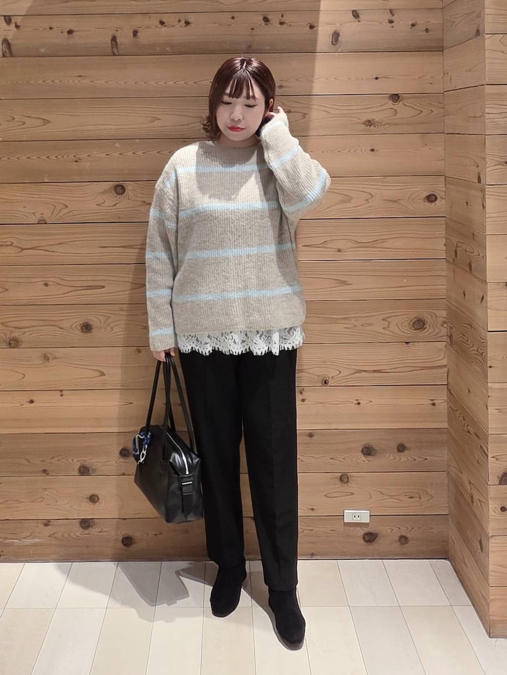 ブラック系のボストンバッグ、グレー系のチェスターコート、ブラック系のその他パンツを着用したレディースの冬コーディネートの4枚目の写真