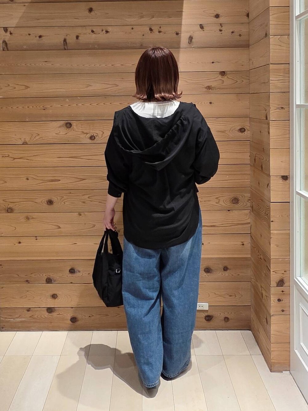 ブラック系のバレエシューズ、ブラック系のトートバッグ、ブルー系のデニムパンツを着用したレディースの春コーディネートの3枚目の写真