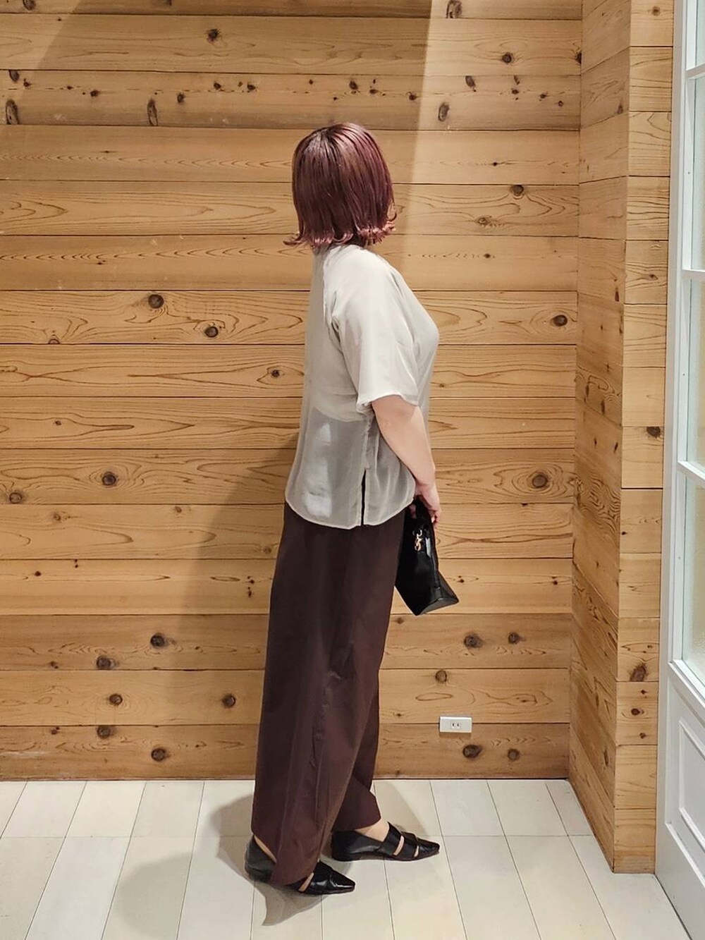 ブラック系のショルダーバッグ、ベージュ系のTシャツ/カットソー、ブラック系のパンプスを着用したレディースの夏コーディネートの2枚目の写真