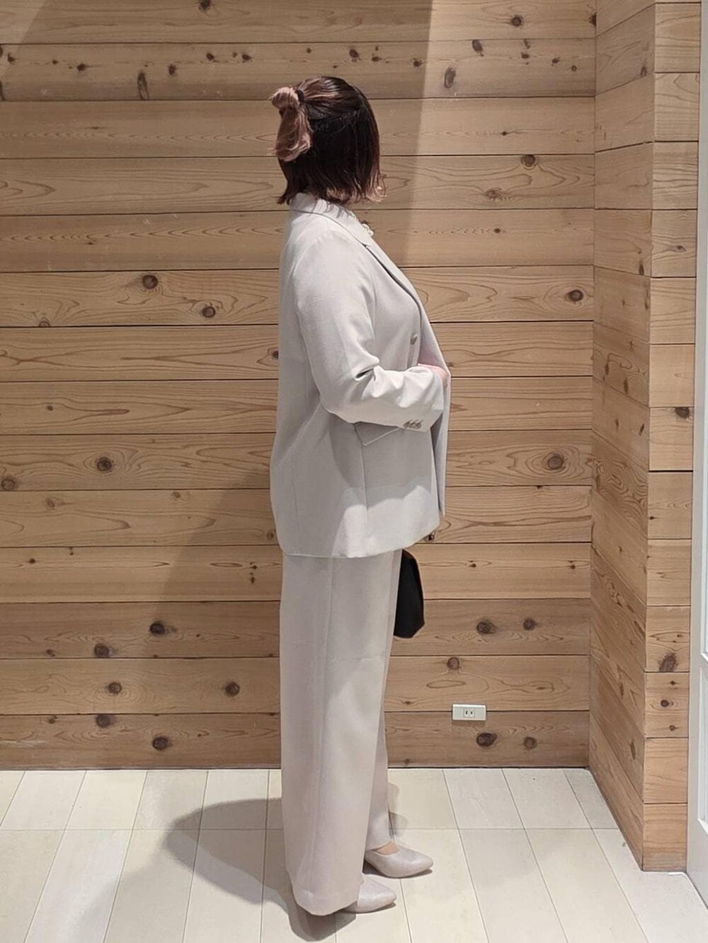 ブラック系のショルダーバッグ、ホワイト系のパンプス、ブルー系のシャツ/ブラウスを着用したレディースの冬コーディネートの2枚目の写真