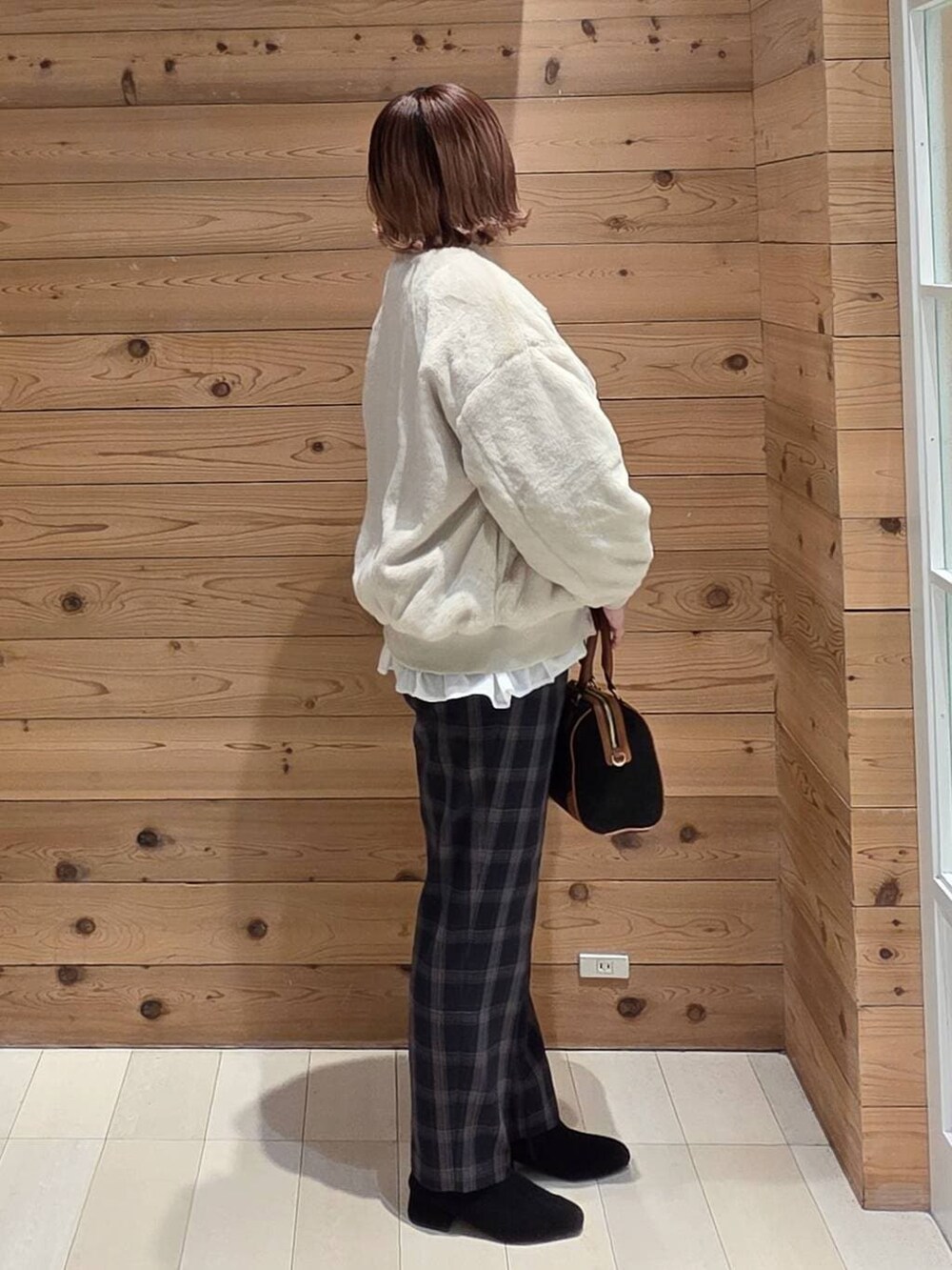 ベージュ系のブルゾン、ブラック系のスウェット、ブルー系のその他パンツを着用したレディースの冬コーディネートの2枚目の写真