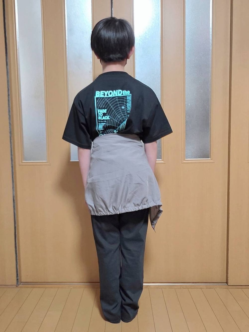 ベージュ系のマウンテンパーカー、ブラック系のデニムパンツ、ブラック系のTシャツ/カットソーを着用したキッズの春コーディネートの3枚目の写真