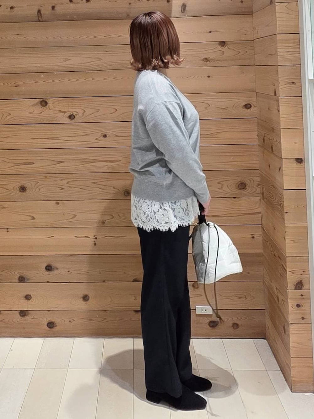 ブラウン系のダウンジャケット/コート、ホワイト系のハンドバッグ、ブルー系のその他パンツを着用したレディースの冬コーディネートの2枚目の写真