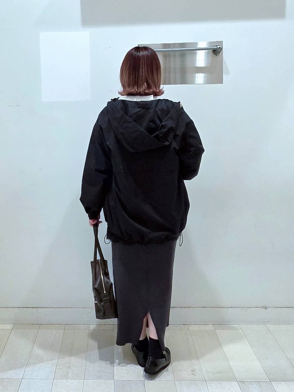 ブラック系のローファー、ブラウン系のボストンバッグ、ブラック系のマウンテンパーカーを着用したレディースの春コーディネートの3枚目の写真