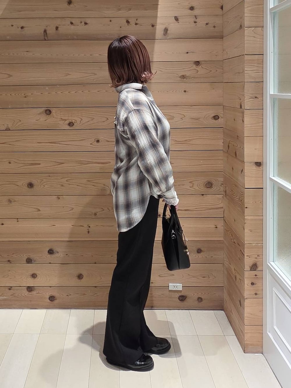 ブラック系のローファー、ブラック系のショルダーバッグ、ホワイト系のTシャツ/カットソーを着用したレディースの春コーディネートの2枚目の写真