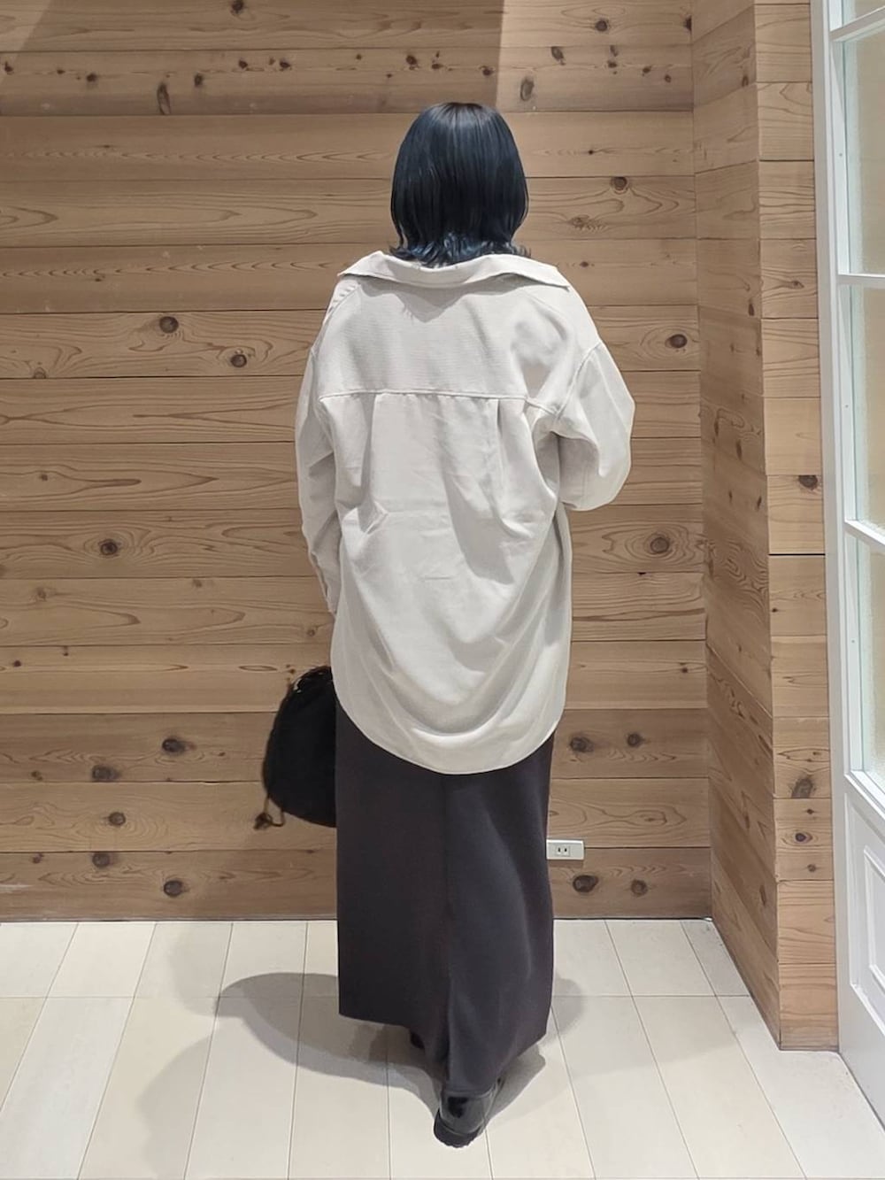 ブラック系のローファー、ブラック系のハンドバッグ、ホワイト系のTシャツ/カットソーを着用したレディースの秋コーディネートの3枚目の写真