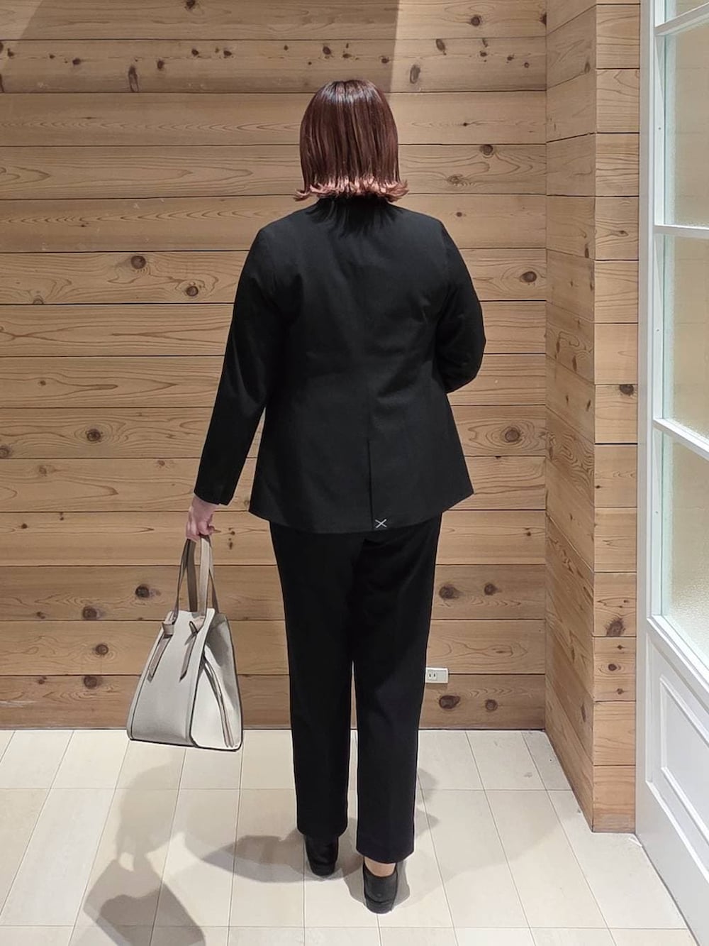 ブラック系のローファー、ホワイト系のショルダーバッグ、ブラック系のスラックスを着用したレディースの冬コーディネートの3枚目の写真