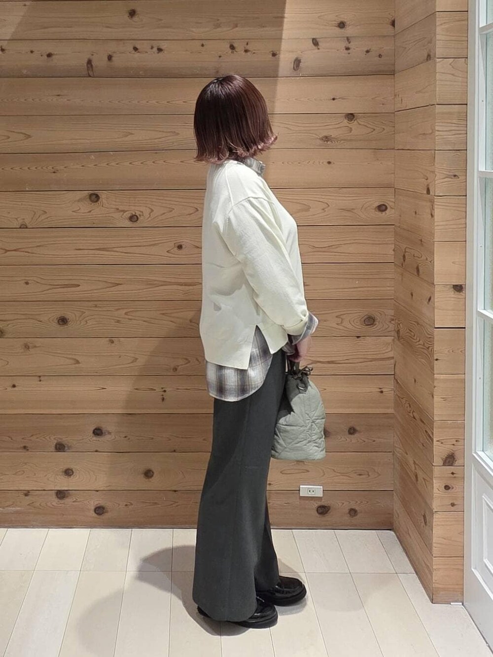 ブラック系のローファー、グリーン系のハンドバッグ、グレー系のその他パンツを着用したレディースの春コーディネートの2枚目の写真