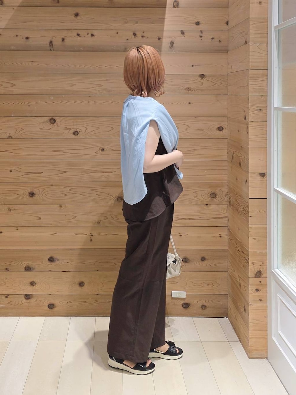 ベージュ系のショルダーバッグ、ブルー系のシャツ/ブラウス、ブラック系のサンダルを着用したレディースの夏コーディネートの2枚目の写真
