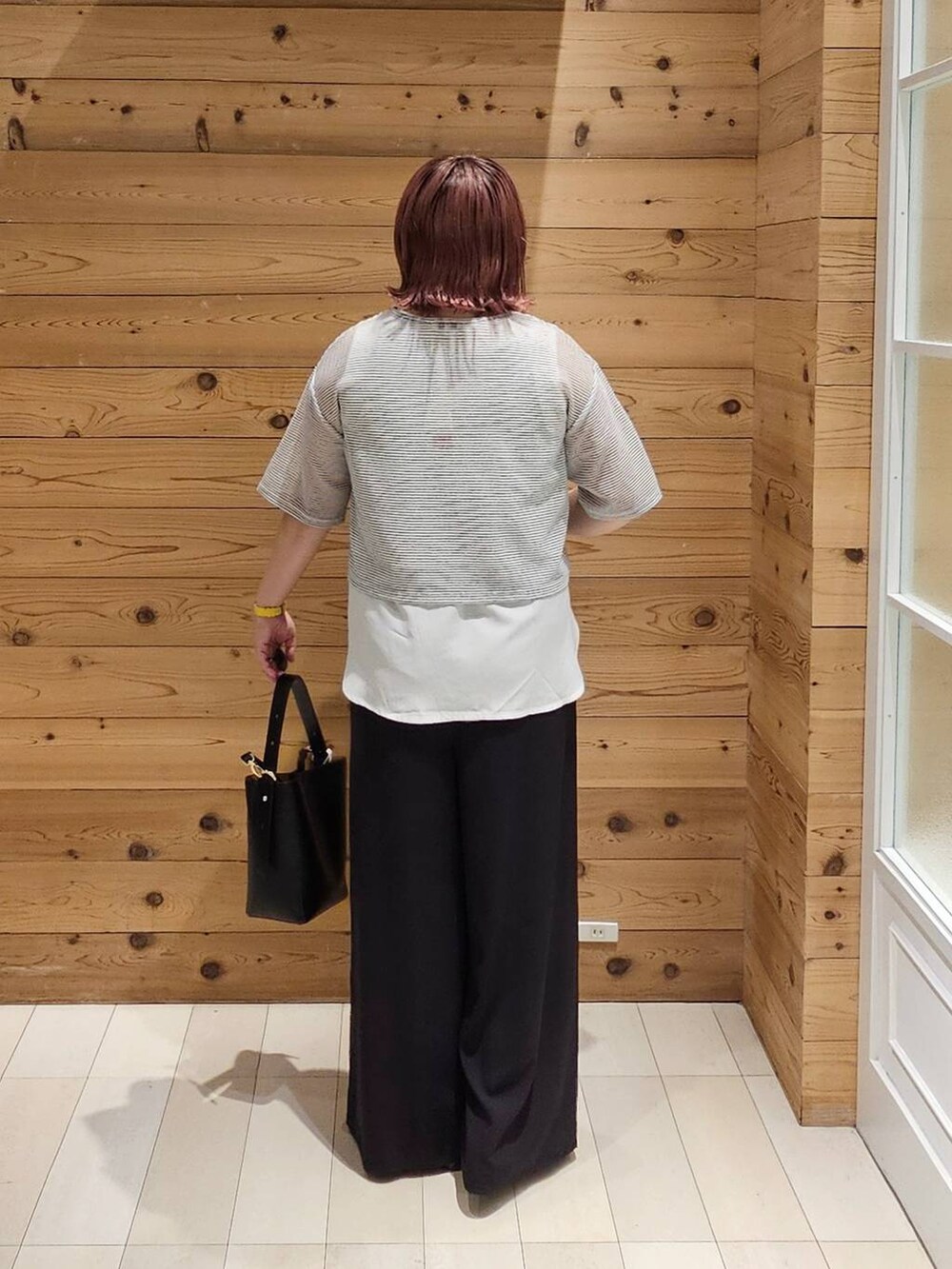 ブラック系のショルダーバッグ、ホワイト系のTシャツ/カットソー、ブラック系のパンプスを着用したレディースの夏コーディネートの3枚目の写真