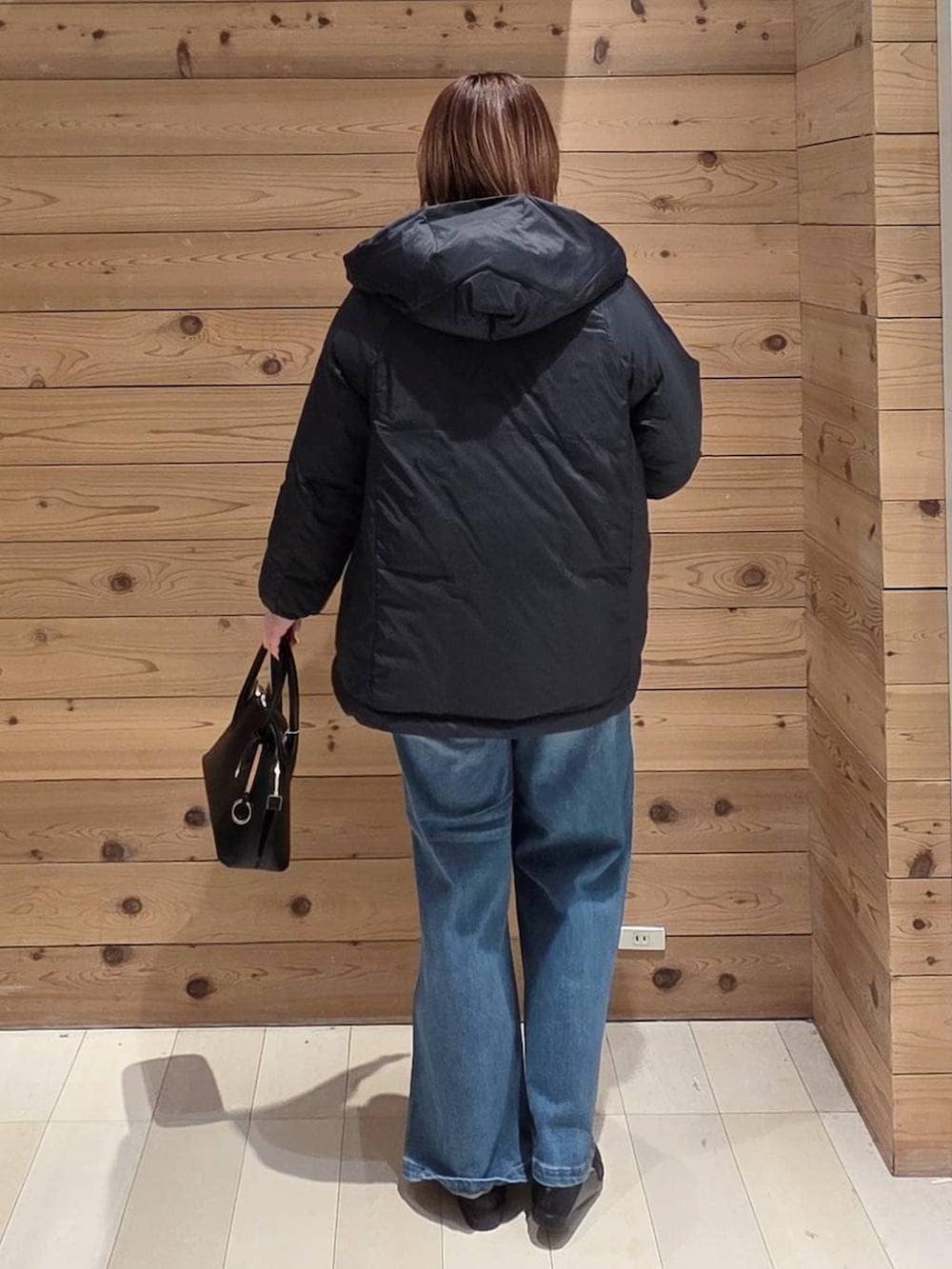 ブラック系のローファー、ブラック系のショルダーバッグ、ブルー系のダウンジャケット/コートを着用したレディースの冬コーディネートの3枚目の写真