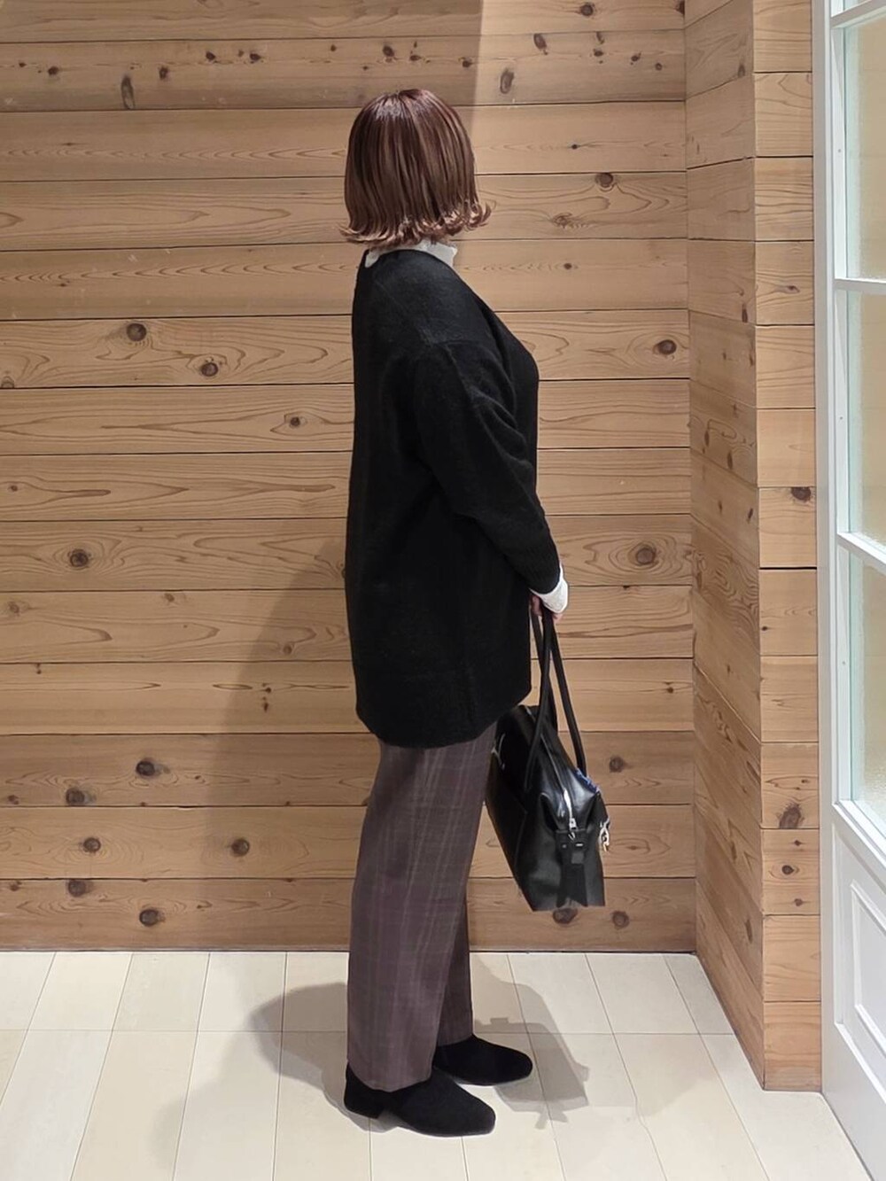 ブラック系のボストンバッグ、ブラック系のダウンジャケット/コート、ブラウン系のその他パンツを着用したレディースの冬コーディネートの2枚目の写真