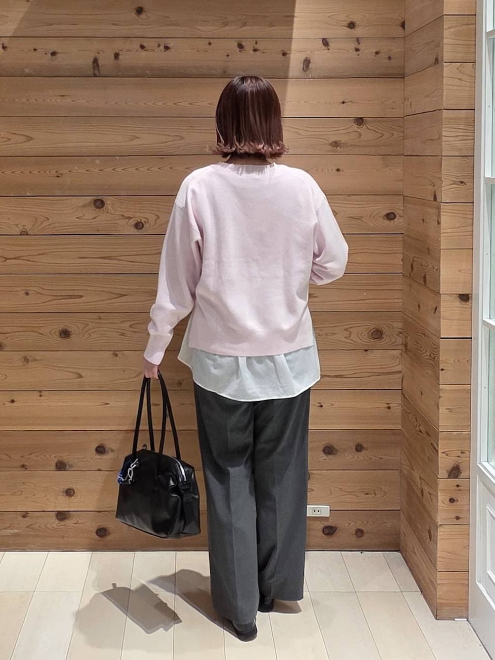 ブラック系のローファー、ブラック系のボストンバッグ、グレー系のスラックスを着用したレディースの春コーディネートの3枚目の写真