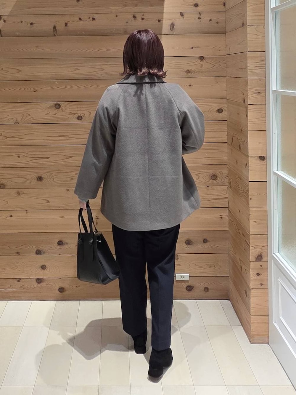 ブラック系のショルダーバッグ、ブラウン系のチェスターコート、ブルー系のその他パンツを着用したレディースの冬コーディネートの3枚目の写真