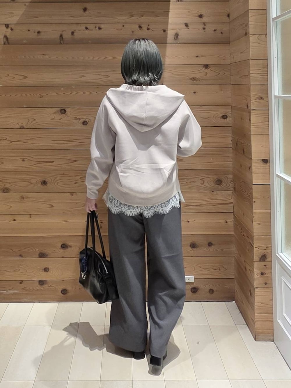 ホワイト系のTシャツ/カットソー、ベージュ系のパーカー、ブラック系のブーツを着用したレディースの秋コーディネートの3枚目の写真